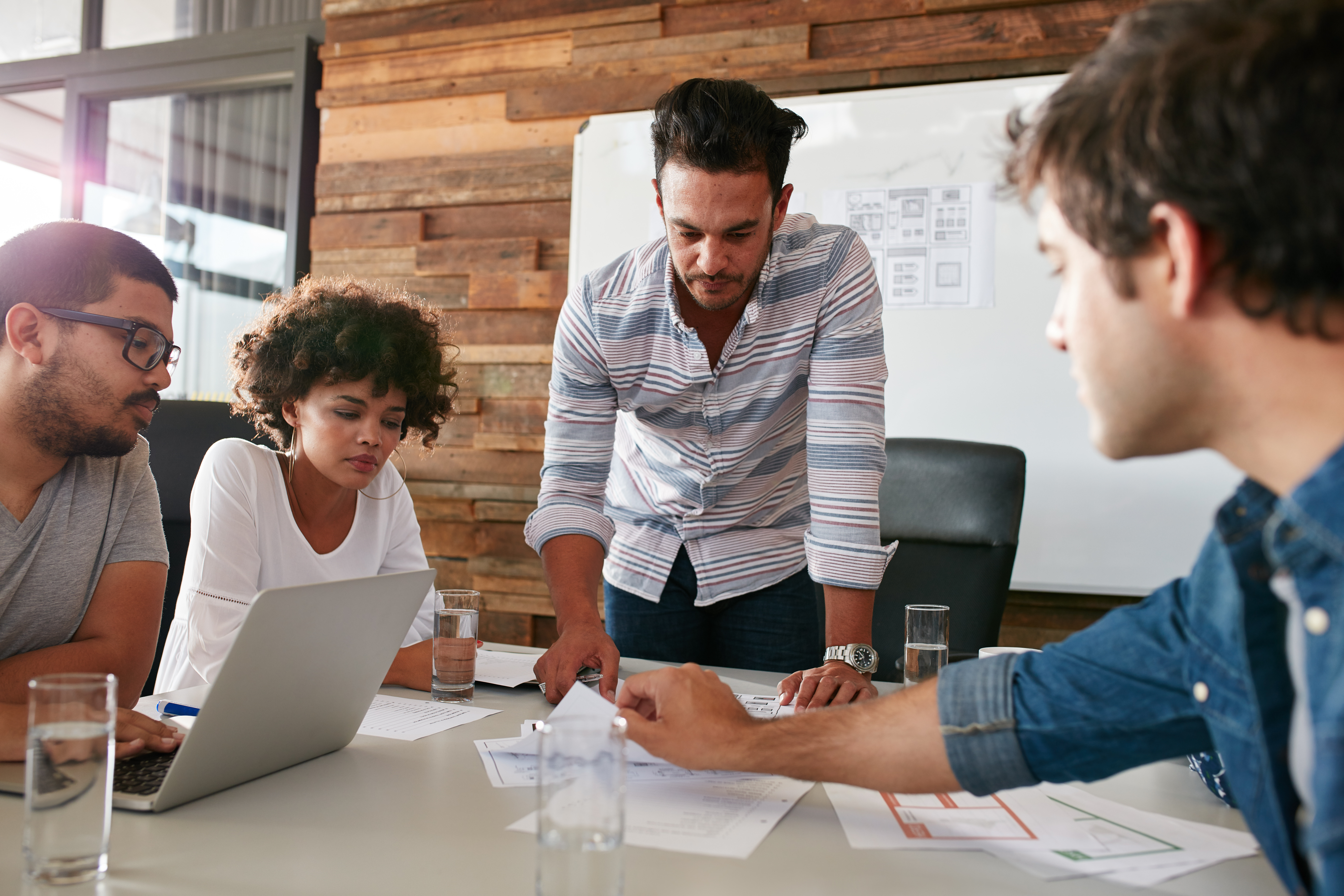 A picture of a digital marketing meeting with four people around a table